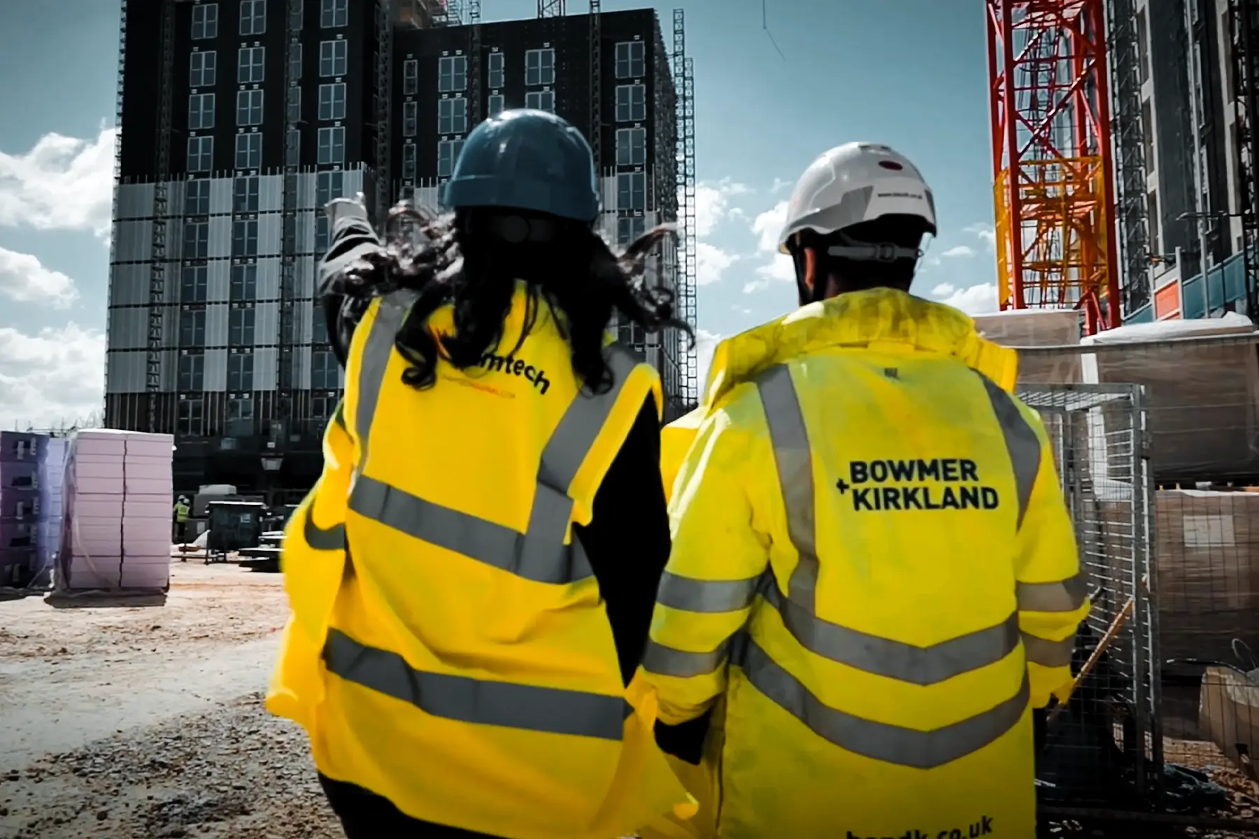 Ramtech and Bowmer and Kirkland staff in hi-vis walking towards apartment blocks at Kirkstall Road, Leeds