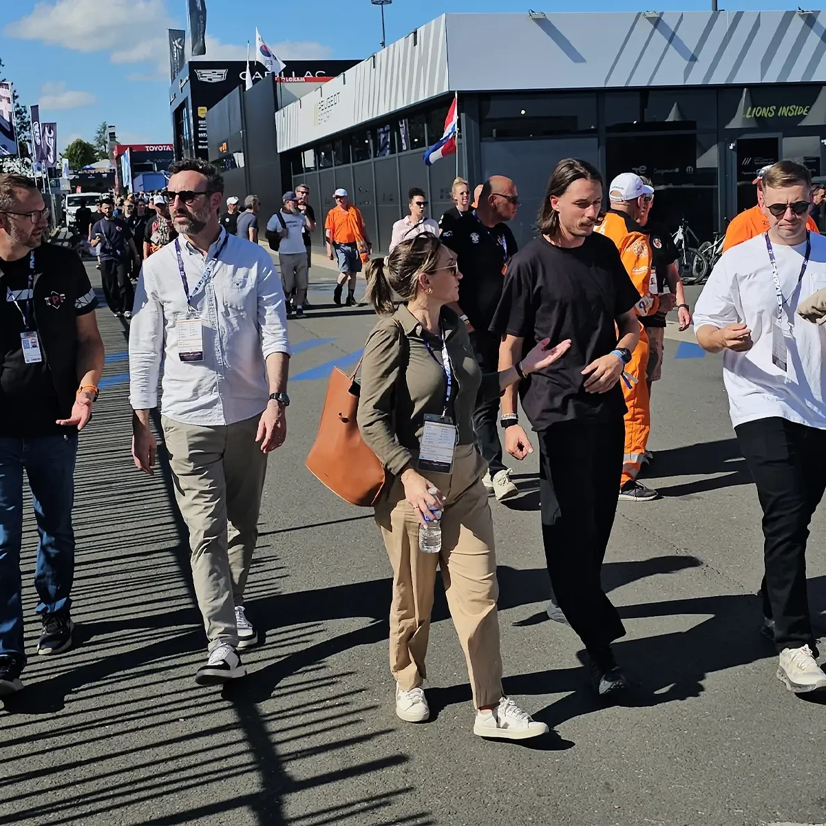 Groupe de membres d'une équipe de projet traversant la zone du paddock du Mans