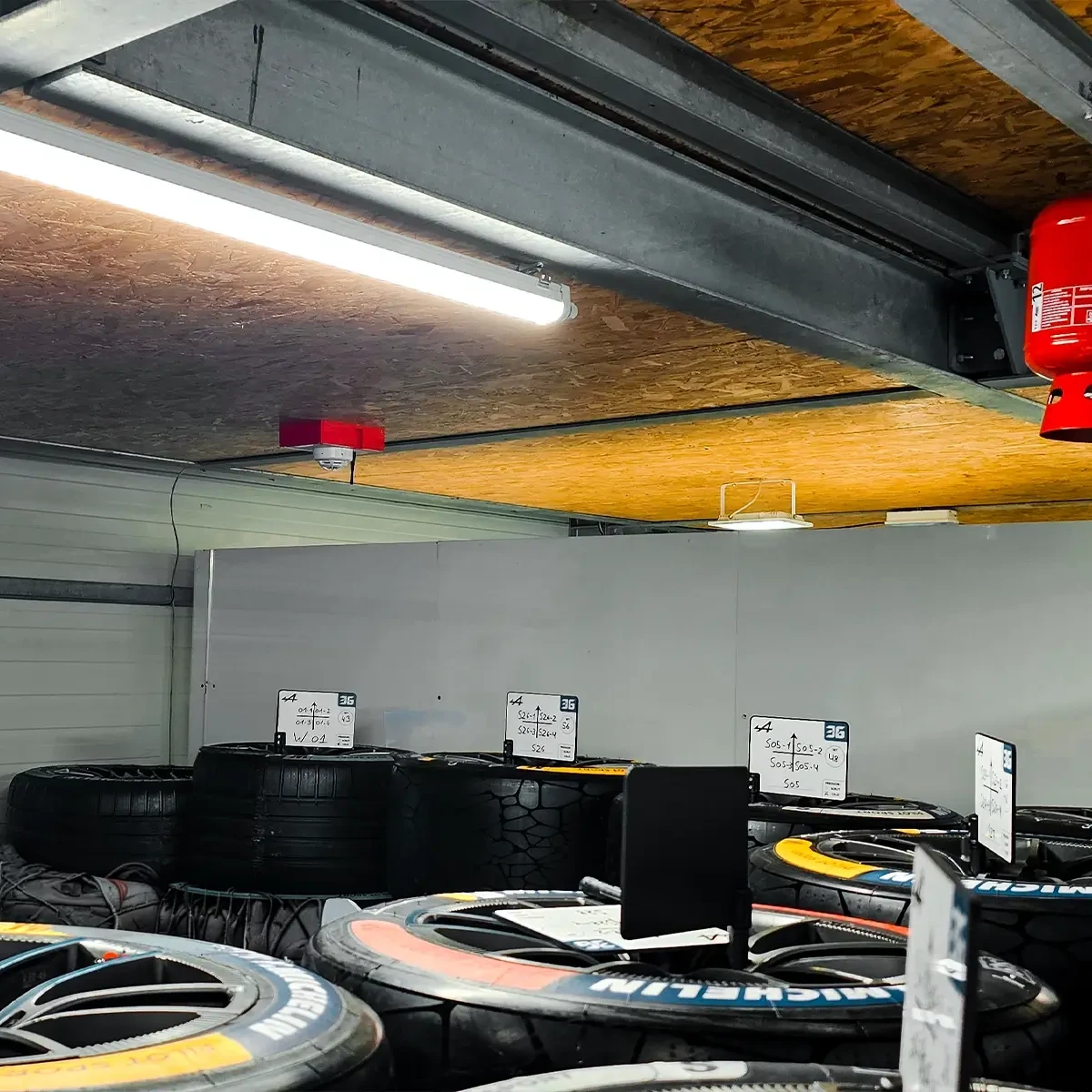 Détecteur WES3 sur le plafond d'un enclos au-dessus de pneus et roues de course empilés